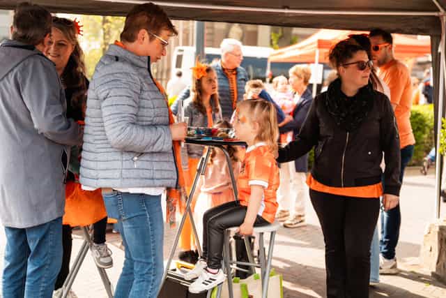 A group of smiling volunteers in orange t-shirts